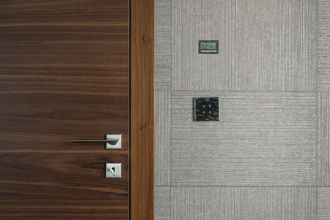 A close up of a wooden door next to a tiled wall