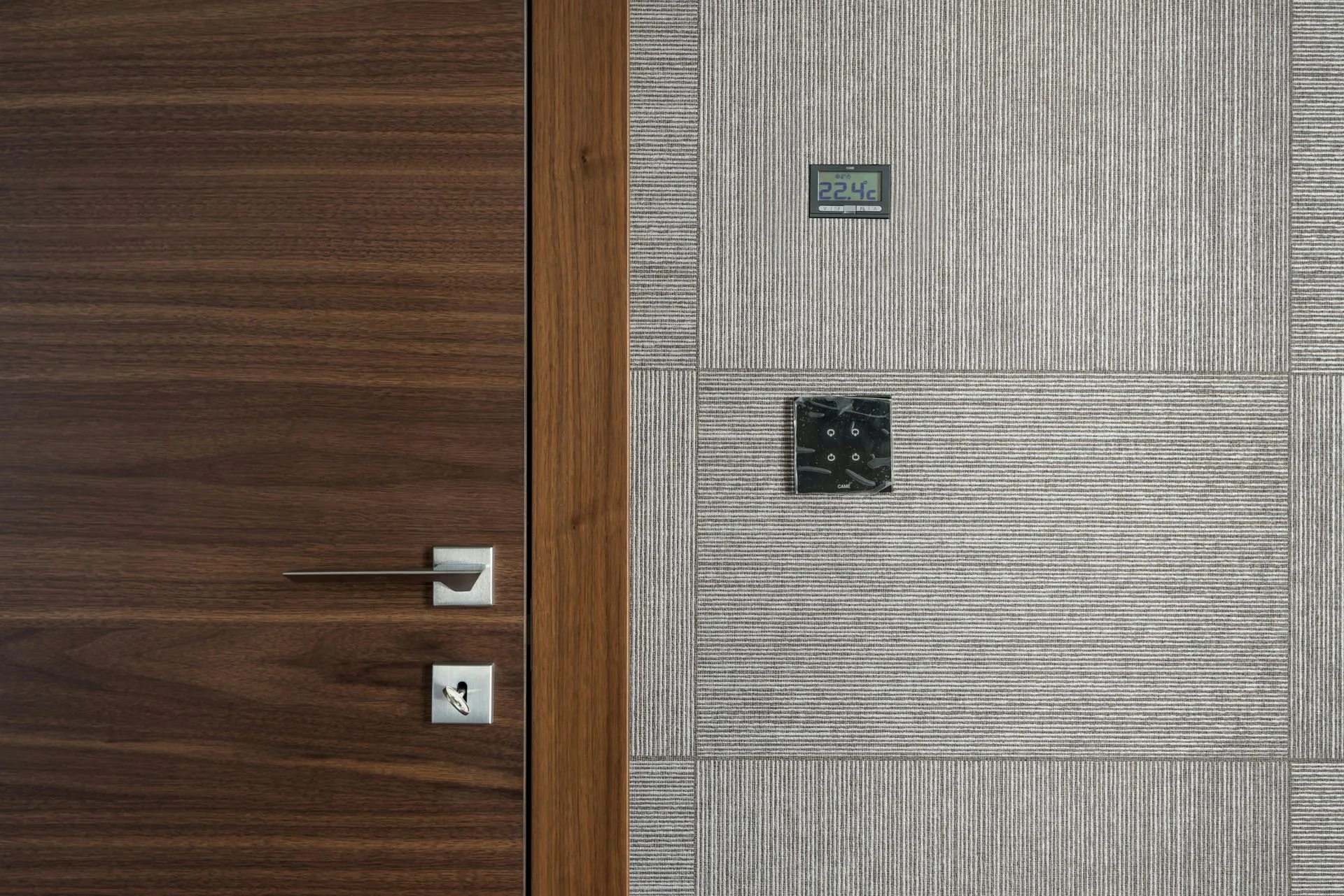 A close up of a wooden door next to a tiled wall