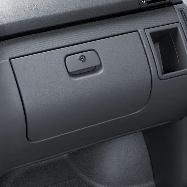 Closed gray car glove compartment on the dashboard, with a small latch and nearby air vent. Closed gray car glove compartment on the dashboard, with a small latch and nearby air vent.